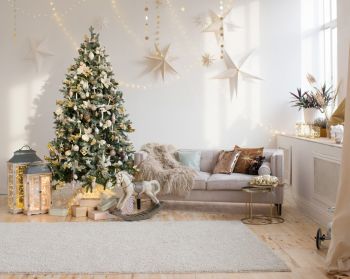 neutral living room with pale wooden floor and a Christmas tree with gold decorations